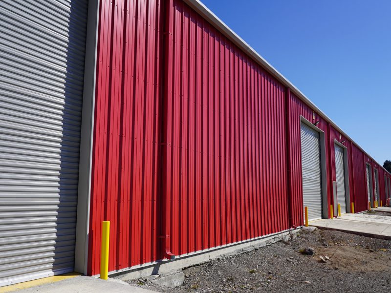 Punta Arenas, Chile storage warehouse with crimson red wall panel, framed opening trims and personnel doors