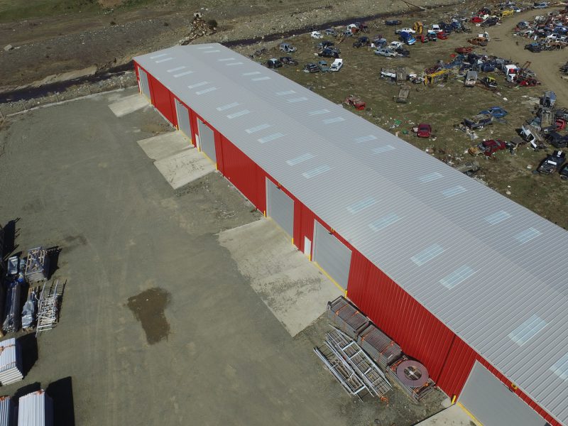 Punta Arenas, Chile storage warehouse with crimson red wall panel and bone white roof and skylights