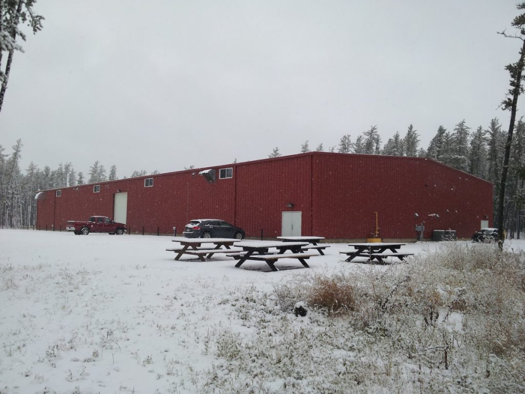 red Indoor steel building riding arena in the snow