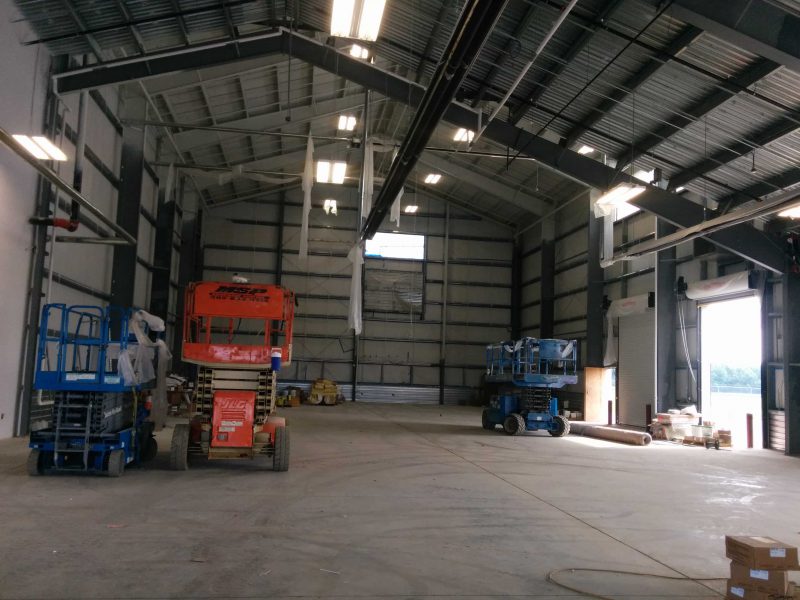 Interior of an industrial hangar with asymmetrical clearspan frame, skylights and overhead doors in Dover, Delaware