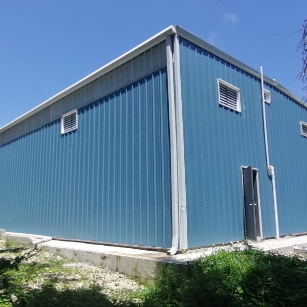 Cobalt blue office metal building with solar white gable trim, framed windows, gutter, downspouts and walk door