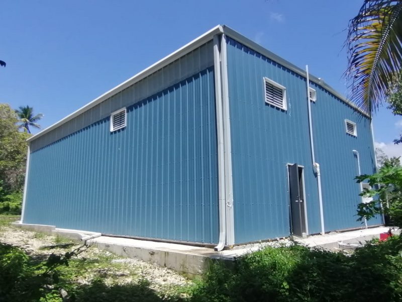 Cobalt blue office metal building with solar white gable trim, framed windows, gutter, downspouts and walk door