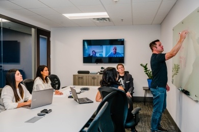 Allied Steel Buildings employes at the office and through video conference attending a meeting.